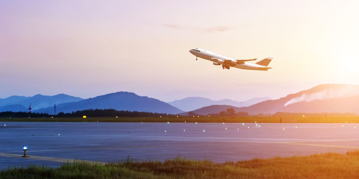 aeroplane taking off with mountains in the distance