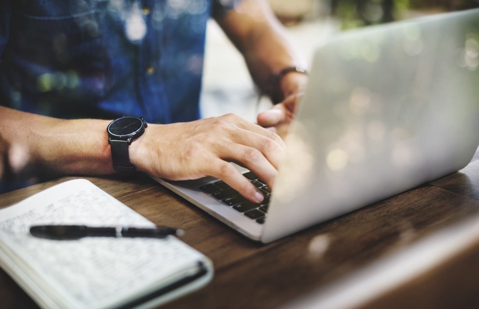 Hands typing on a laptop