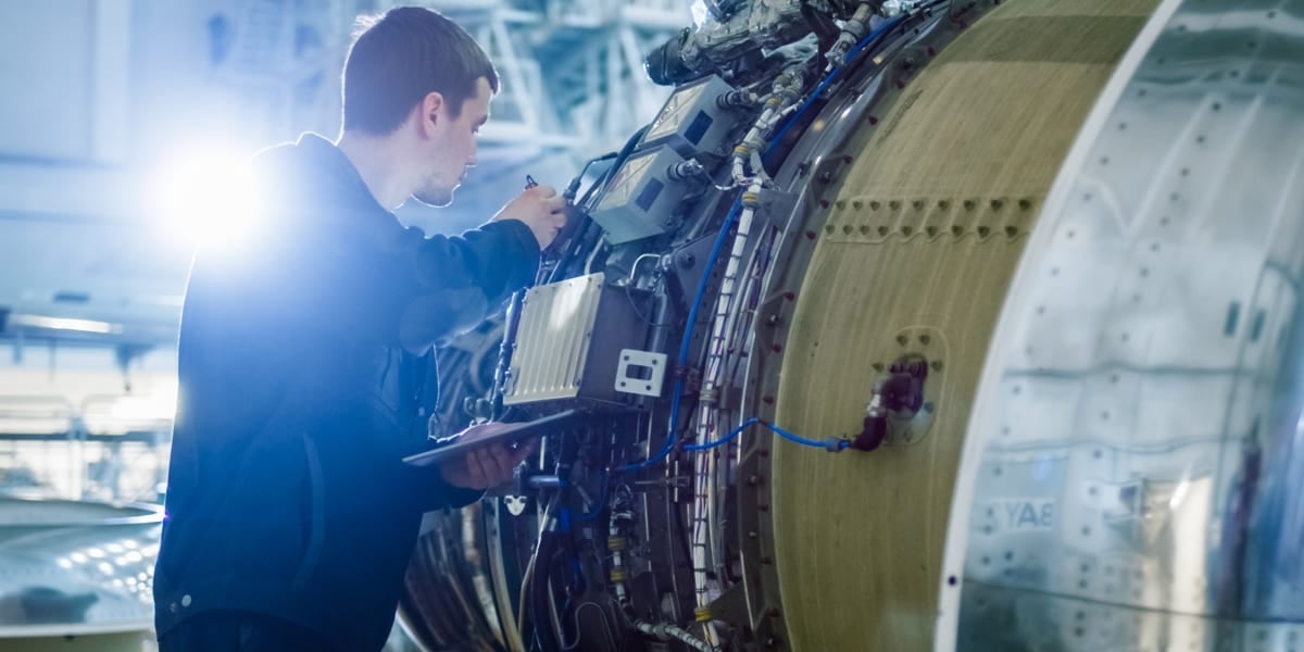 male engineer working on aeroplane engine