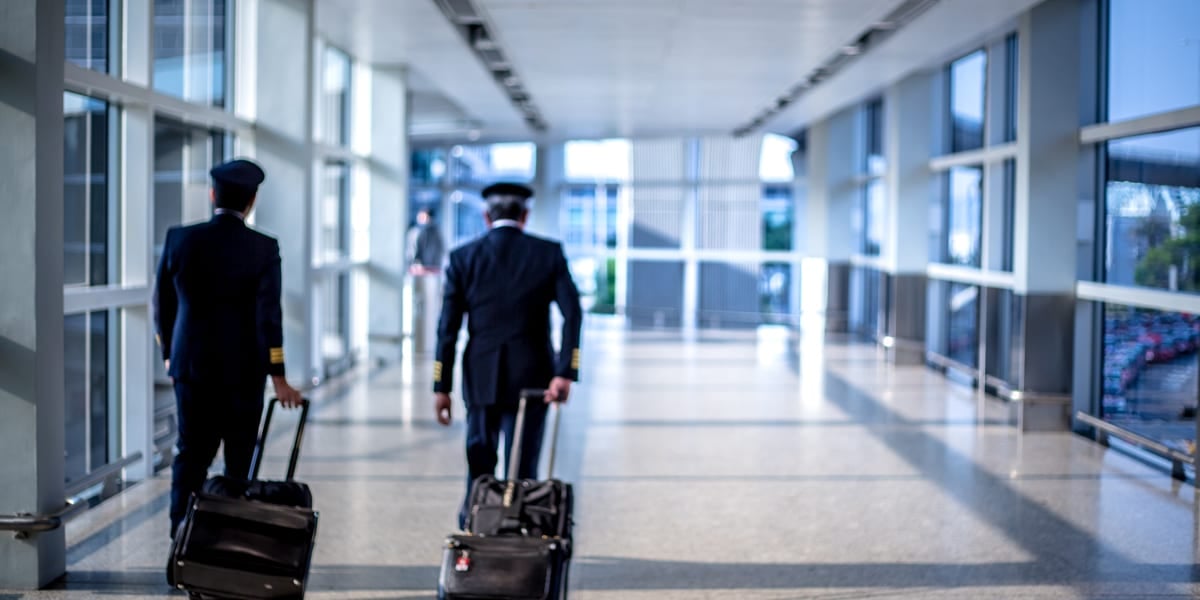 two pilots walking away with suitcases