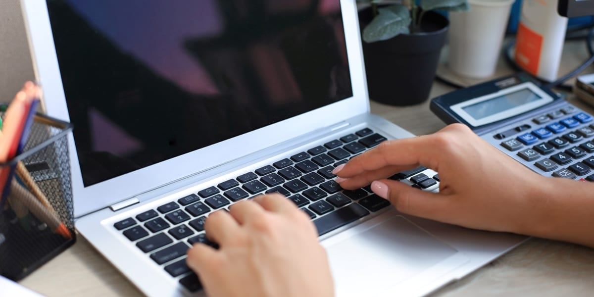 female hands typing on laptop keyboard