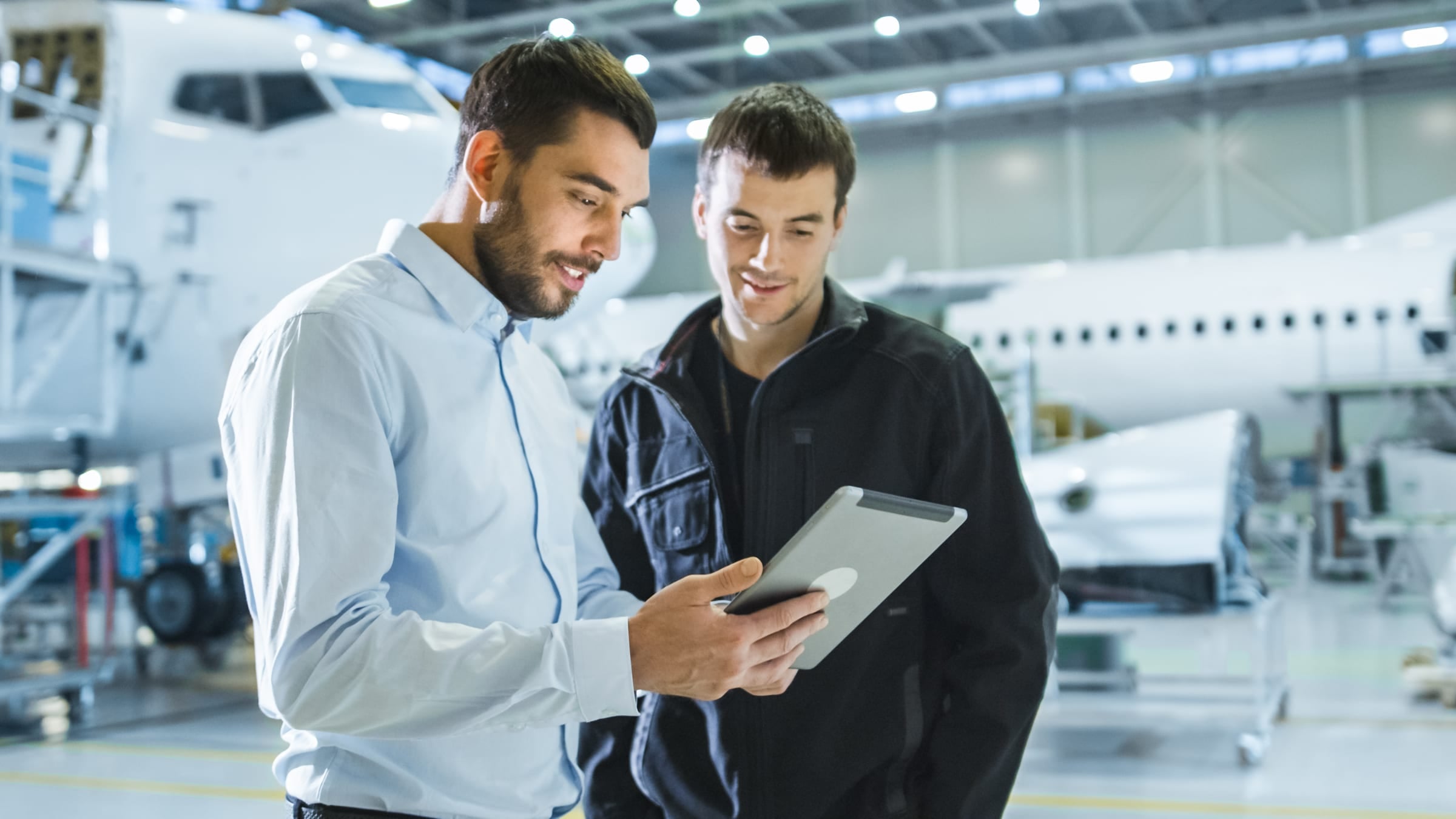 two men looking at an ipad