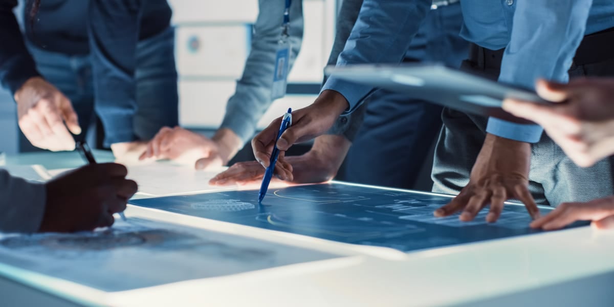 hands on table and pointing at plans